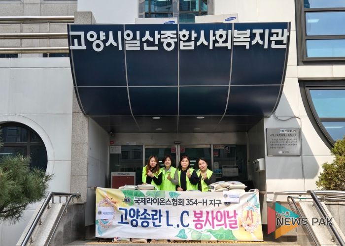 고양시일산종합사회복지관 입구에서 고양송란라이온스클럽 회원들이 전달한 쌀과 함께 사진을 촬영하고 있다.