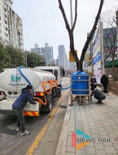 동행정복지센터 앞에 설치된 유용미생물(EM)탱크에 유용미생물(EM) 발효액을 공급하고 있다.