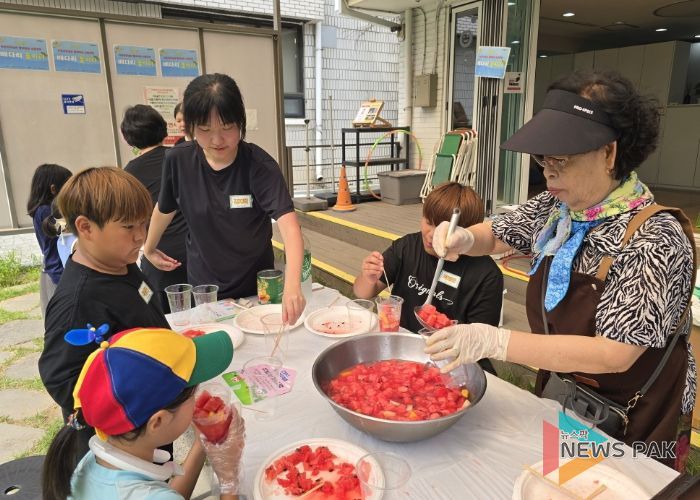 '우리마을 은빛 놀이터’프로그램에 참여한 어르신이 아이들에게 수박화채를 나눠주고 있다.