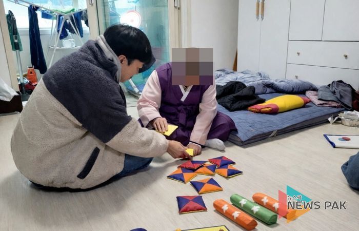 치매 어르신과 후견인이 딱지치기 등 전통놀이를 체험하고 있다.