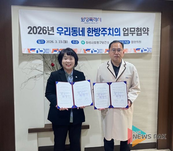 유종우 효행구보건소장과 명한의원 윤탁현 원장이 업무협약을 체결하고 협약서를 들고 기념촬영을 하고 있다